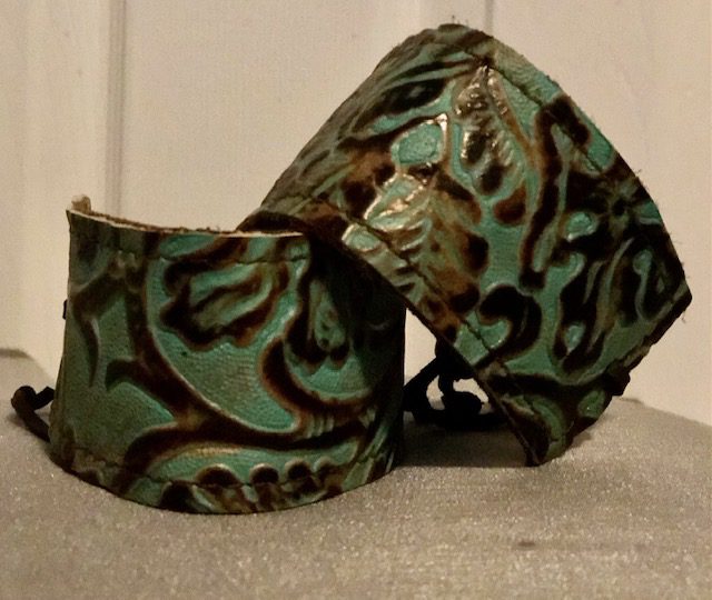 A pair of green and brown bracelets sitting on top of a table.