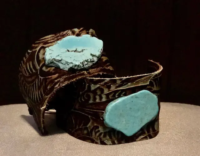 A pair of bracelets with turquoise stones on them.