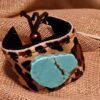 A close up of a bracelet with a turquoise stone