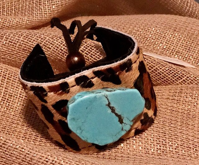 A close up of a bracelet with a turquoise stone
