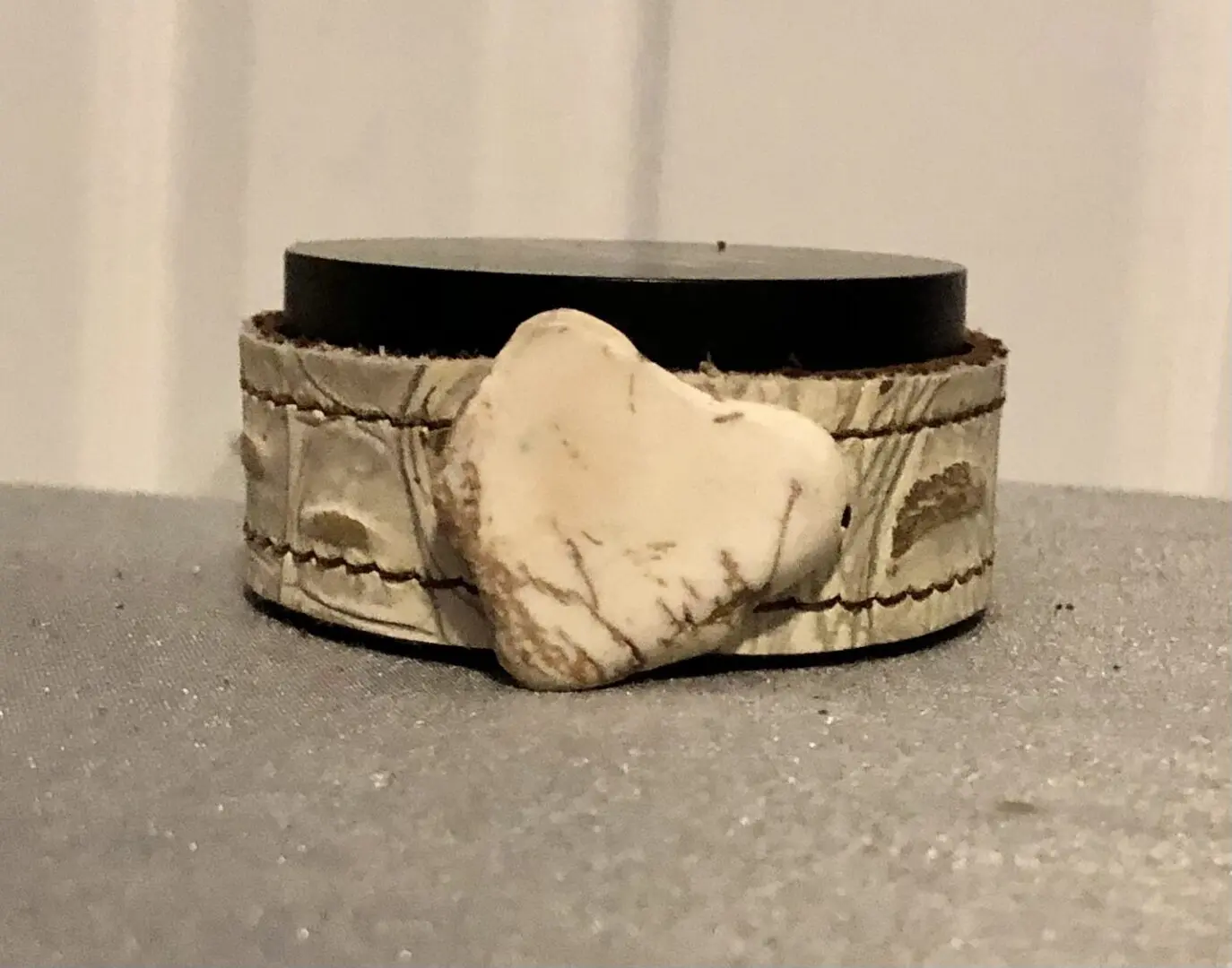 A white stone is on top of the bracelet.