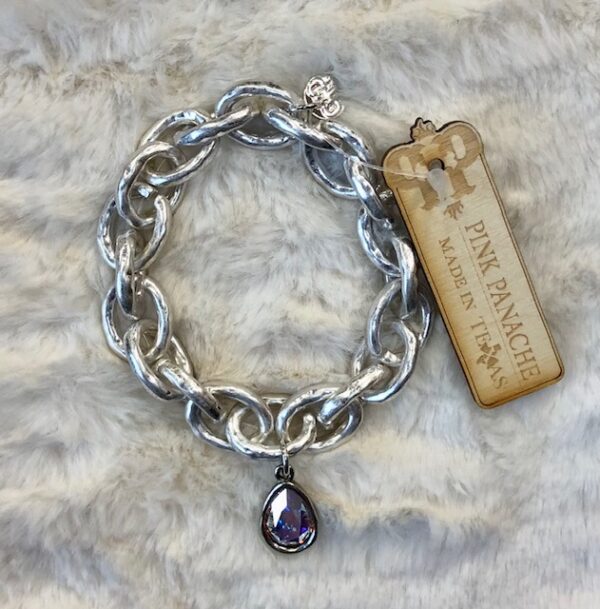 A chain link bracelet with a purple stone charm.