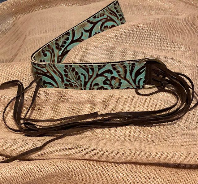 A brown and blue bracelet on top of a blanket.