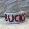 A white and red bracelet with the word bucks written in it.