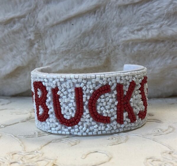 A white and red bracelet with the word bucks written in it.