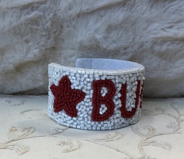 A white bracelet with red stars and the word " buzz ".