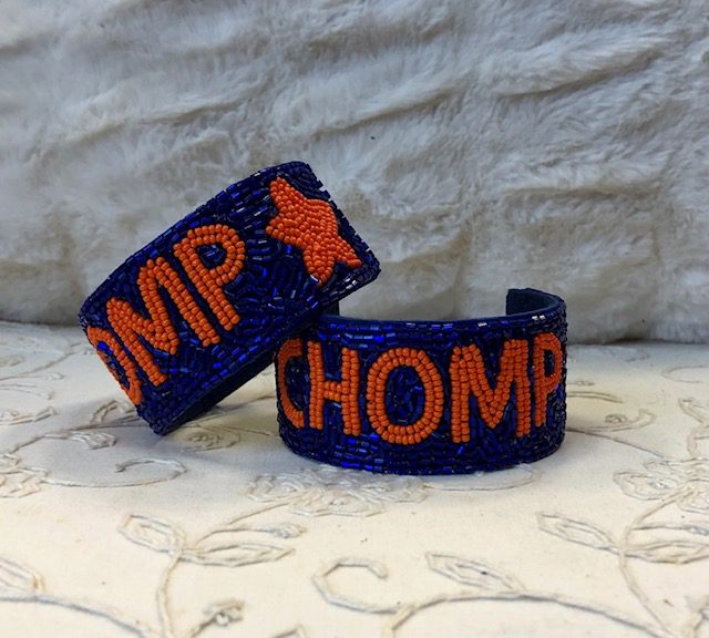 A pair of blue and orange bracelets sitting on top of a bed.