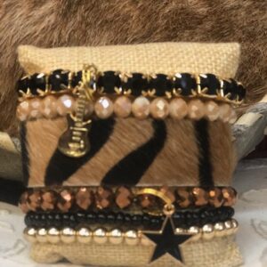 A small pillow with many different bracelets on it