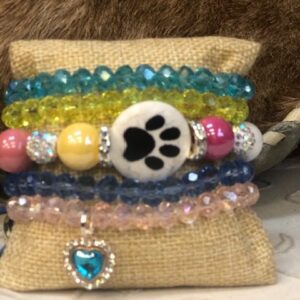 A stack of bracelets with a paw print on it.