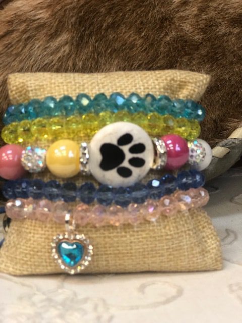A stack of bracelets with a paw print on it.