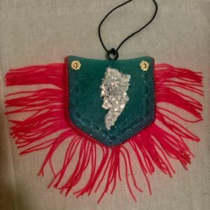 A Jean Pocket Freshie with red and green fringes on it.