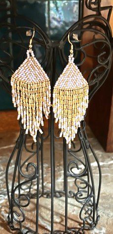 A pair of earrings sitting on top of a black stand.