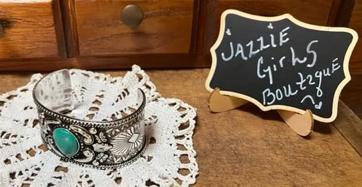 A cup sitting on top of a doily next to a sign.