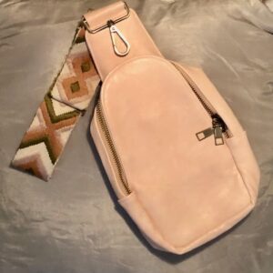 A pink bag with a strap on it