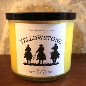 A jar of YellowStone 3 Wick Candle on a table.