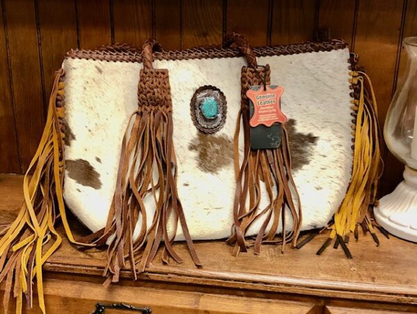 A purse with tassels and some stones on it
