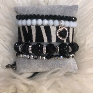 A bracelet that is on top of a white and black blanket.