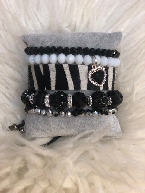A bracelet that is on top of a white and black blanket.