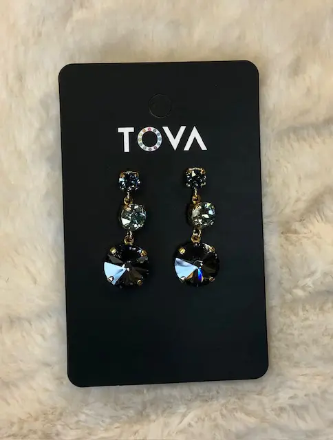 A pair of earrings on top of a card.