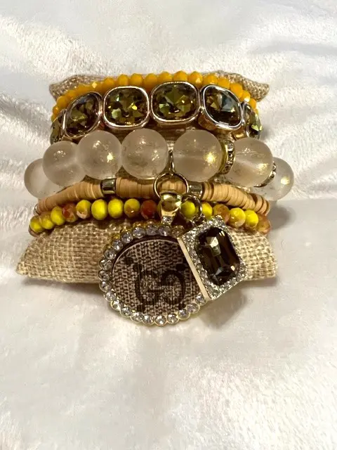 A set of GOLD UPCYCLED BRACELET STACK with yellow beads and a charm.