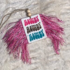 A pink and blue Howdy Howdy Howdy  Freshie ornament with fringes on it.