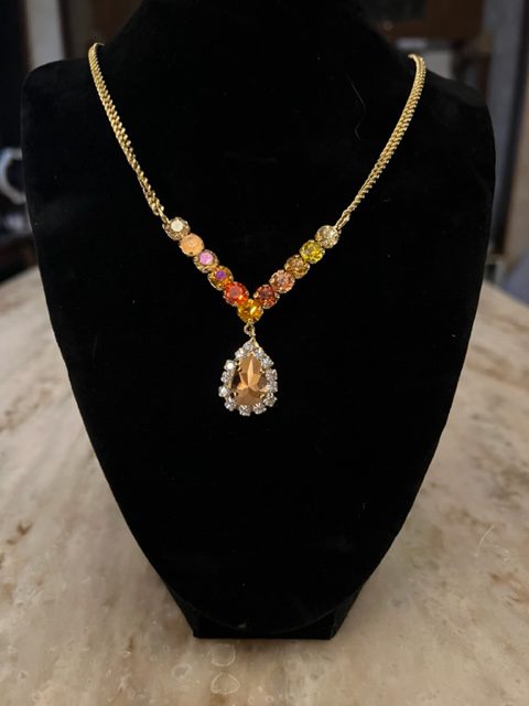 An IVO necklace in fire with a yellow and orange stone.
