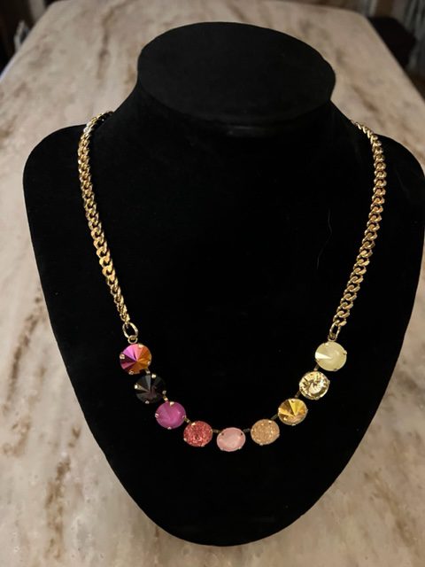A MINI SOFIA IN GOLD PINK OMBRE necklace with multiple colored stones on a mannequin.