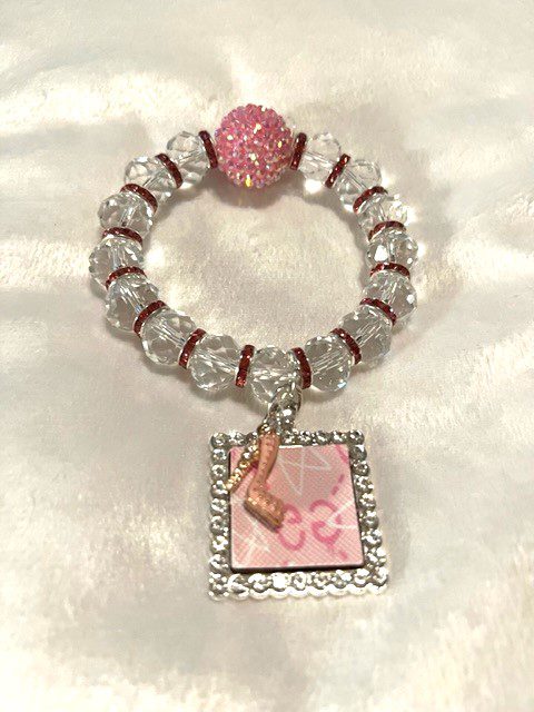 A PINK BLING JAZZIE BRACELET with a pink charm and a pink ribbon.