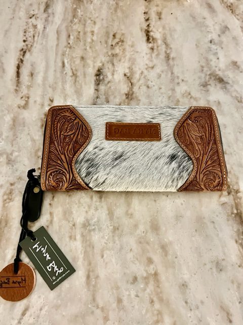 A HAND TOOLED WALLET with a tag on it.