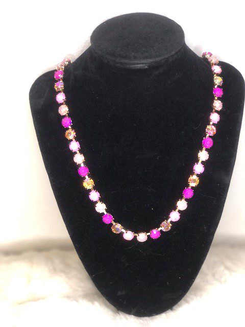 A Myra Fuchsia Gem Necklace with pink and pink beads on a mannequin.