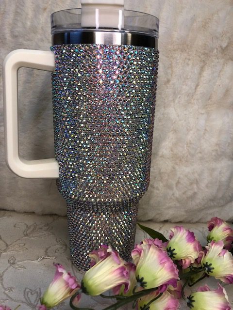 A BLING TUMBLER with rhinestones and flowers.