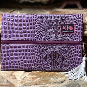 A BUBBLE GATOR AMETHYST MAKEUP BAG with a tassel.