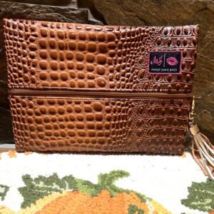 A brown BUBBLE GATOR COGNAC MAKEUP BAG with a tassel.