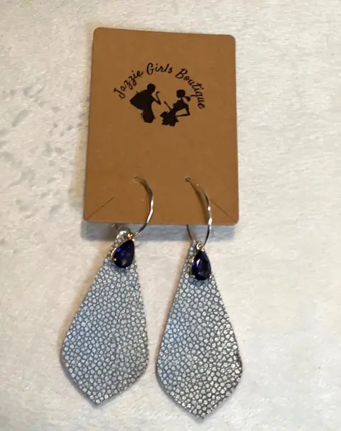 A pair of STING RAY GRAY JAZZIE EARRINGS with blue stones on them.