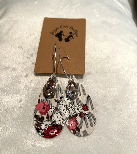 A pair of MK CREAM JAZZIE EARRINGS with floral designs on them.