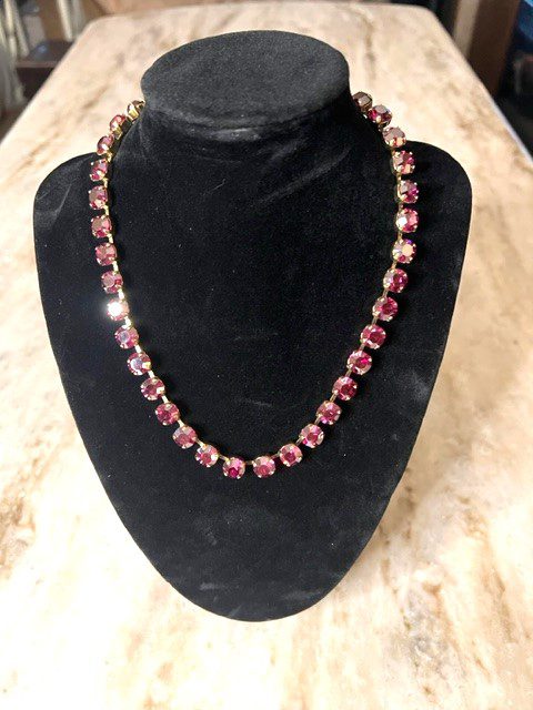 An OAKLAND NECKLACE IN RUBY PINK on a mannequin.
