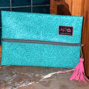 A TURQUOISE DREAM MAKEUP BAG with a pink tassel.