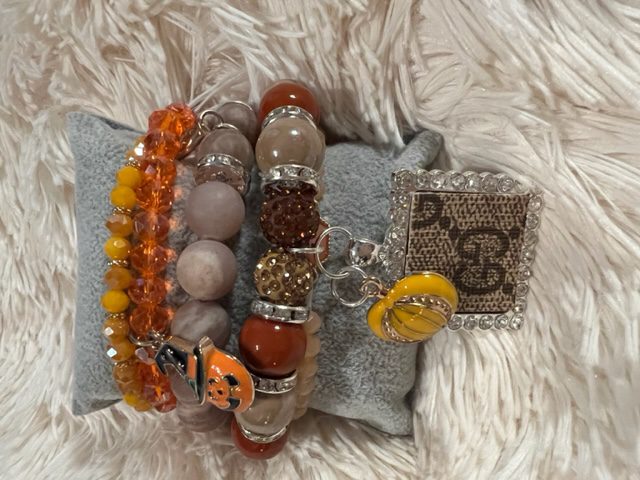 A group of JAZZIE GIRLS FALL STACK BRACELET on a pillow.